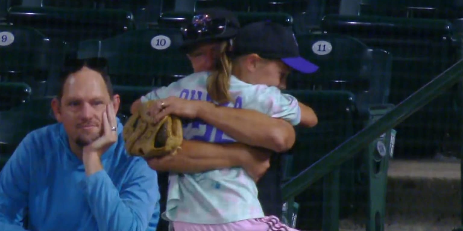 Young fan snags foul ball at Coors Field, celebrates with a loved one in a perfect moment